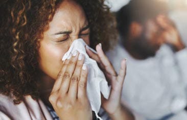 A woman blowing her nose