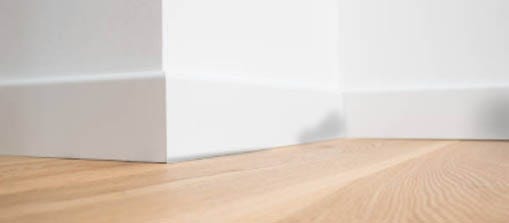 A rodent rub mark against a white baseboard
